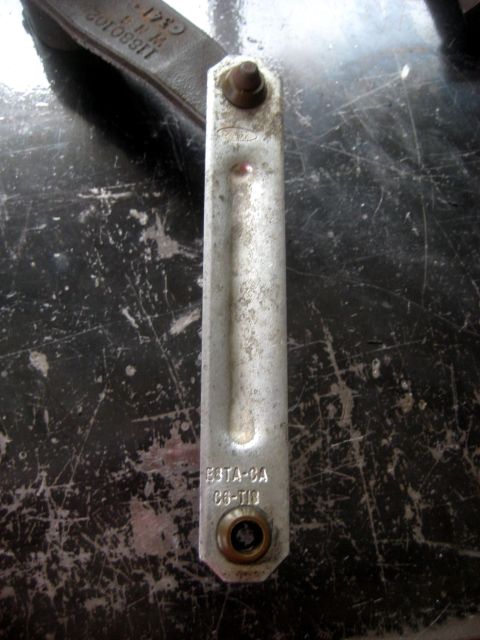 1996 Ford Bronco - A metal bracket with Ford part numbers is shown against a dark, scratched background.
