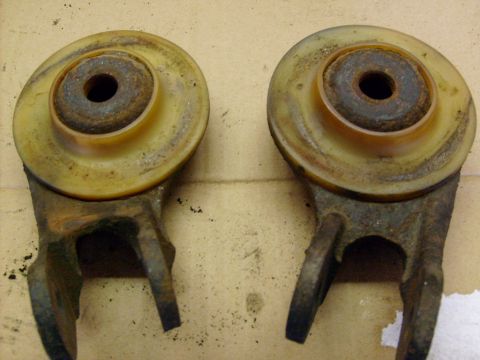 1986 Ford Bronco - Two rusty suspension components are shown, likely from a vehicle's undercarriage.