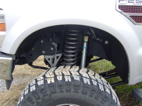 2007 Ford Mustang - The front wheel well of a pickup truck reveals its heavy-duty suspension system, including a prominent coil spring and shock absorber.