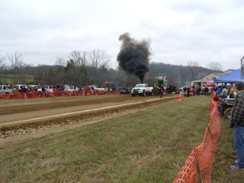 2007 Ford Mustang - A truck emits a large cloud of black smoke during a pull event, with spectators lining the track.