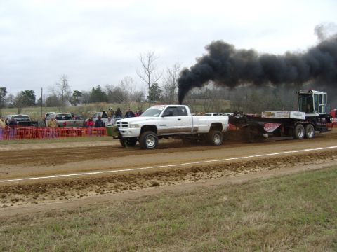 2007 Ford Mustang - A white pickup truck competes in a pull event, emitting a large cloud of black smoke.