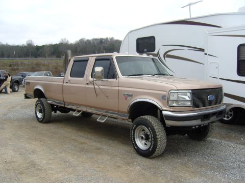 2007 Ford Mustang - This lifted Ford F-250 Super Duty truck is parked next to a large RV.