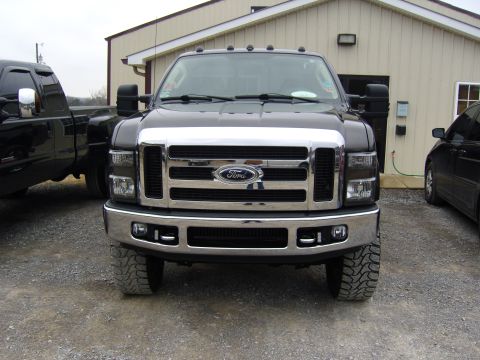 2007 Ford Mustang - Frontal view of a Ford Super Duty truck, parked next to another vehicle.