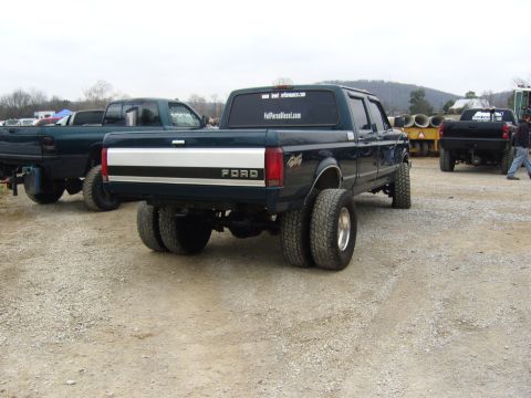 2007 Ford Mustang - A dark teal Ford F-Series dually truck is parked outdoors with other vehicles nearby.