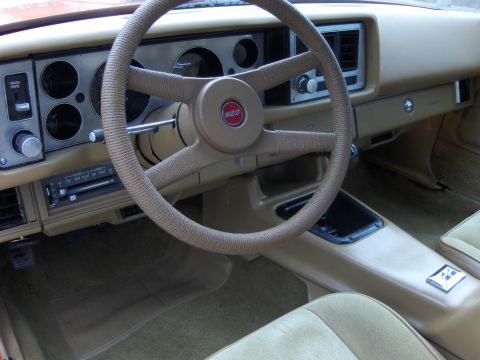 1979 Chevrolet Camaro - The interior of a 1979 Chevrolet Camaro shows a tan dashboard, steering wheel, and seats.