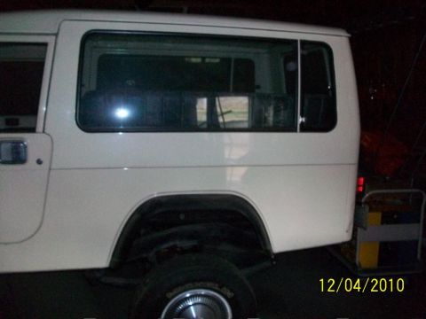 1986 Jeep Wagoneer - Side view of a white 1986 Jeep Wagoneer, showing the rear door and window.