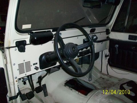 1986 Jeep Wagoneer - The interior of a 1986 Jeep Wagoneer, its dashboard, steering wheel, and pedals.