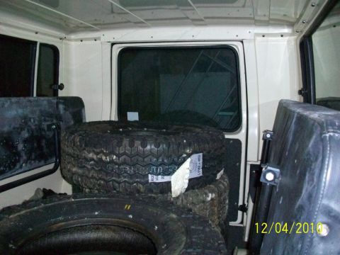 1986 Jeep Wagoneer - Spare tires are stacked inside the cargo area of a vehicle, with seats visible.