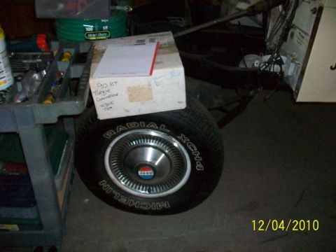 1986 Jeep Wagoneer - A close-up of a Jeep wheel and tire, with a box and tools in the background.