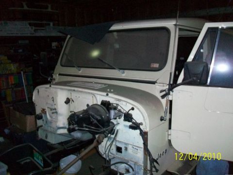 1986 Jeep Wagoneer - This Jeep CJ-8 Scrambler is missing its hood, revealing the engine compartment and various components.