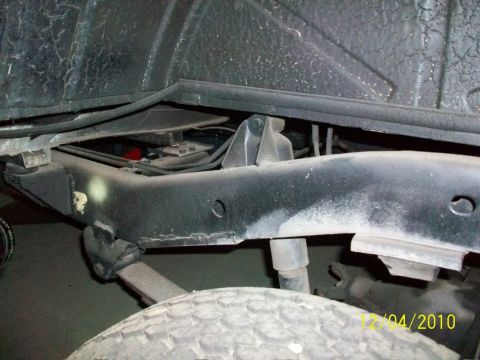 1986 Jeep Wagoneer - Close-up view of the undercarriage of a vehicle, focusing on the frame and suspension system.