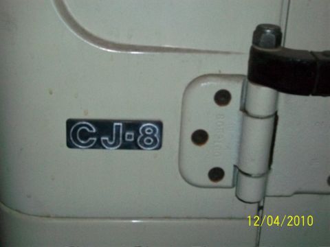 1986 Jeep Wagoneer - Close-up of a CJ-8 badge on a Jeep door, with a visible door hinge.