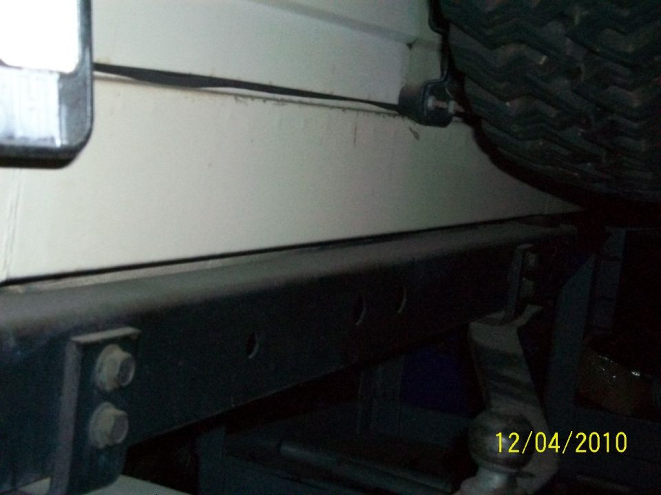 Cream-colored Jeep body panel with a black bumper and tire visible