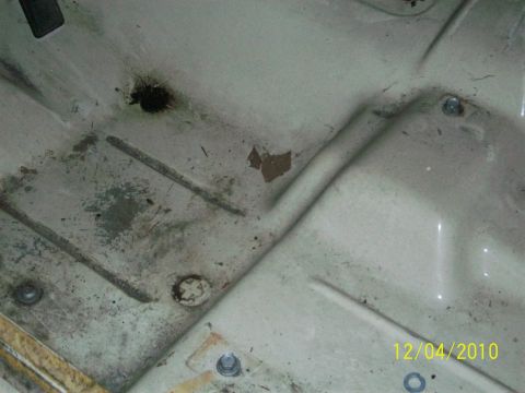 1986 Jeep Wagoneer - The underside of a vehicle's hood shows signs of wear and tear, with rust spots and dirt accumulation.