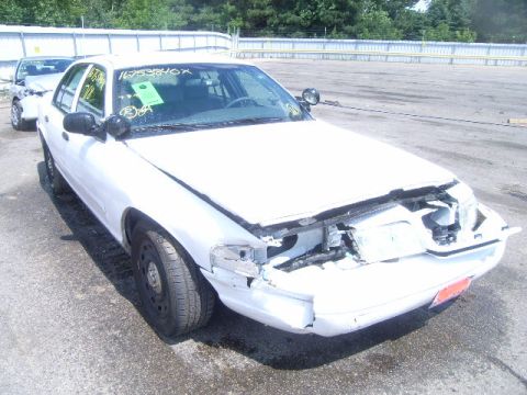 2003 Ford Crown Victoria - Front view of a damaged 2003 Ford Crown Victoria, showing extensive damage to the front bumper and hood area.