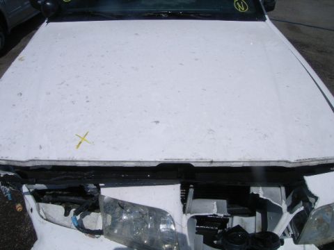 2003 Ford Crown Victoria - Front view of a damaged white car, showing the hood and partially visible headlights.