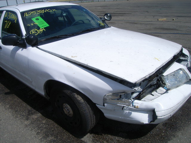 White sedan, front end smashed in, hood up, driver's side mirror intact