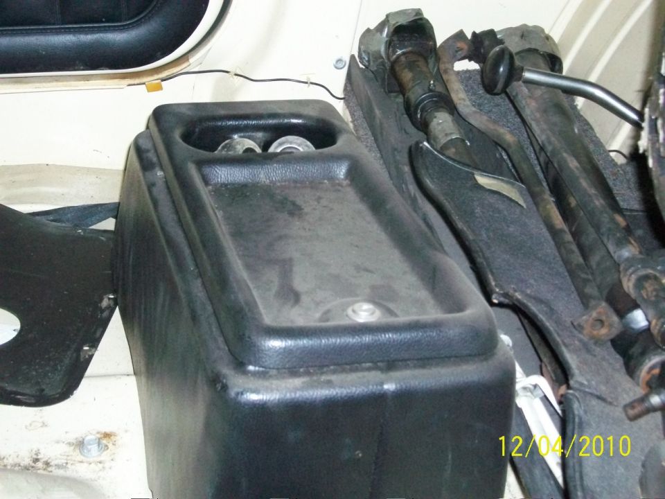 Interior view of a vehicle's center console and floor shifter assembly with a SuperMotors watermark