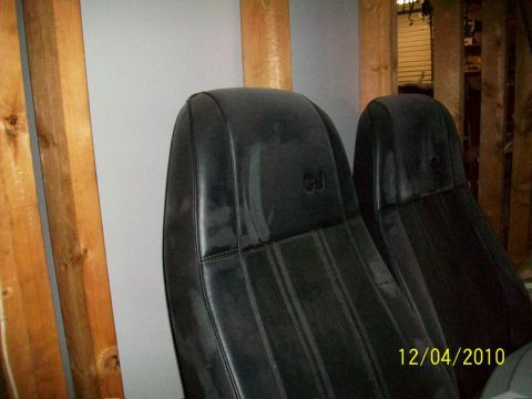 1986 Jeep Wagoneer - Close-up of two black Jeep seats, possibly from a CJ model, with visible stitching and a "CJ" emblem on the headrests.