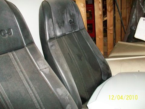 1986 Jeep Wagoneer - Close-up of two black Jeep CJ seats, showing wear and embossed lettering.