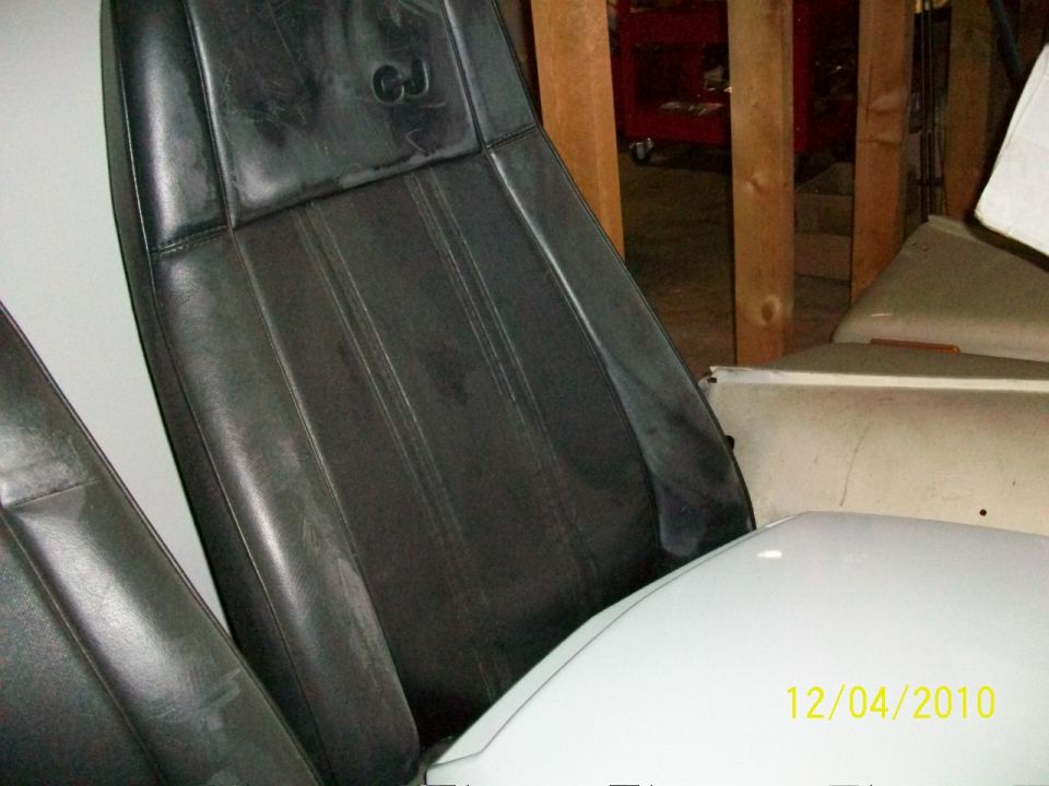 Close-up of black leather seats with a CJ logo embossed on the headrest