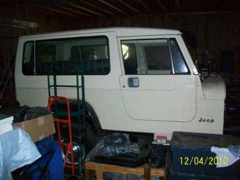1986 Jeep Wagoneer - A white Jeep SUV is parked indoors, partially obscured by various items. The date 12/04/2010 is visible on a watermark.