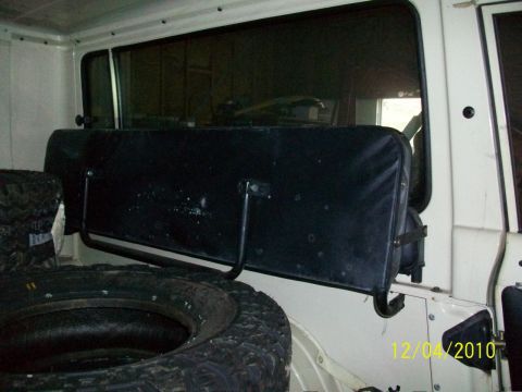 1986 Jeep Wagoneer - The interior of a vehicle shows a spare tire and a folded rear seat.