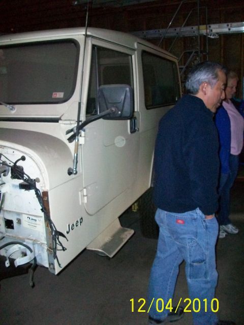 1986 Jeep Wagoneer - Cream Jeep CJ-8 Scrambler with front end removed, showing its side profile and 'Jeep' badging.