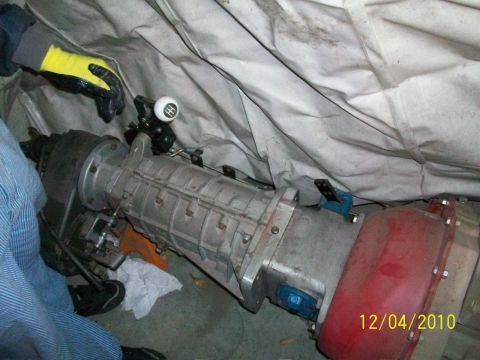 1986 Jeep Wagoneer - A transmission and shifter are visible, partially covered by a tarp. The shifter knob has a gear pattern.