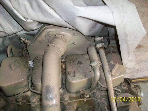1986 Jeep Wagoneer - Close-up view of an engine block, partially covered by a tarp, with various hoses attached.