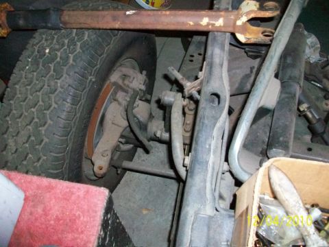1986 Jeep Wagoneer - Close-up of the front suspension and tire assembly on a 1986 Jeep Wagoneer.