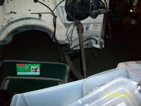 1986 Jeep Wagoneer - Close-up of a Jeep's engine bay, showing mechanical parts and storage containers.