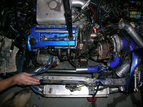 1995 Ford Probe - Custom turbo setup in an engine bay with blue intercooler piping and a blue valve cover.