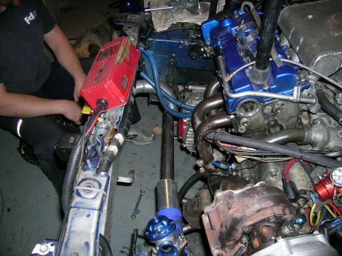 1995 Ford Probe - Mechanic working on custom turbo setup in a vehicle's engine bay.