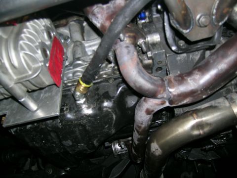 1995 Ford Probe - Close-up view of engine components, including the oil pan and exhaust system.