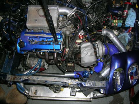 1995 Ford Probe - Customized engine bay with a prominent turbocharger and intercooler setup.