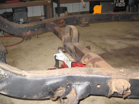 1963 Ford Galaxie - Vehicle frame sections are shown on jack stands in a workshop setting.