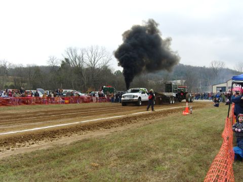 2007 Ford Mustang - A truck and tractor compete in a pull, kicking up a large cloud of black smoke as they move down the dirt track.