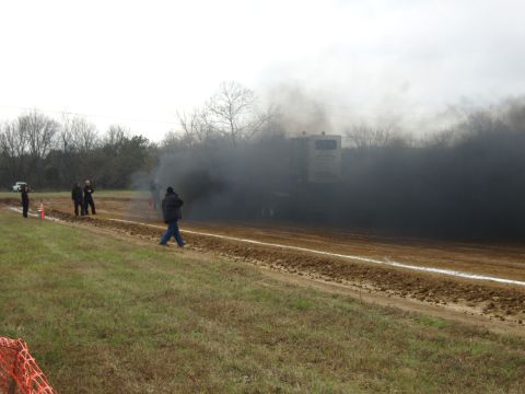 2007 Ford Mustang - Tractor pulling event with heavy smoke and onlookers present.