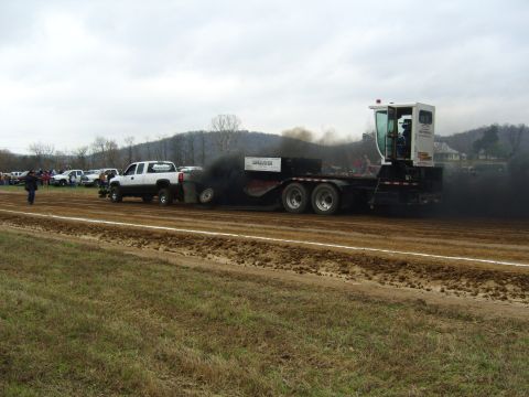 2007 Ford Mustang - A tractor pulls a trailer, emitting a large cloud of black smoke during a competition.