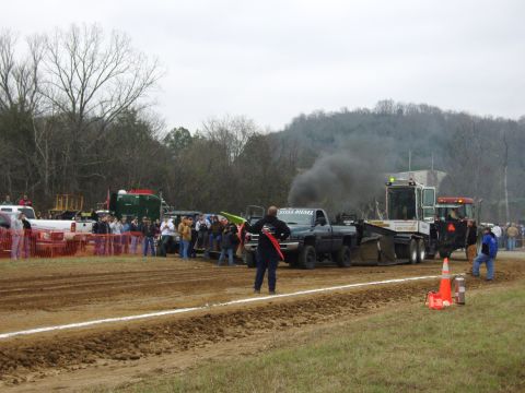 2007 Ford Mustang - A truck pulls a sled during a competition, emitting a large cloud of black smoke.