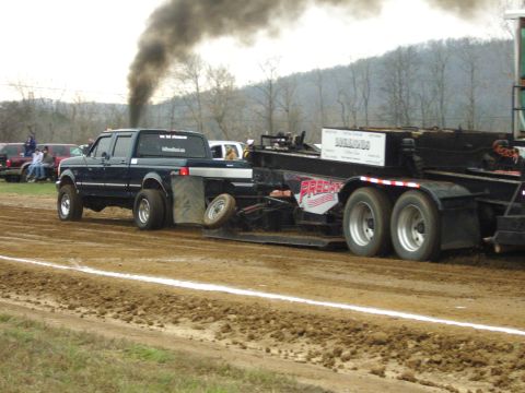 2007 Ford Mustang - Ford F-Series truck competes in a pull, kicking up dirt and smoke.