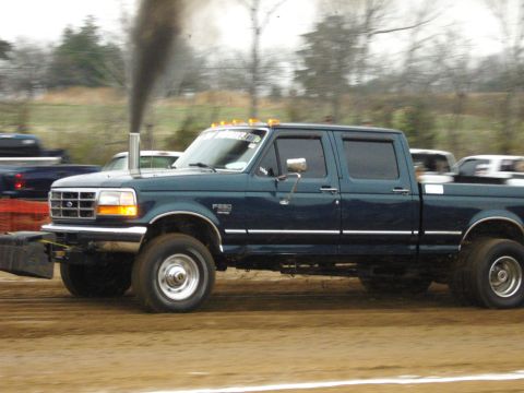 2007 Ford Mustang - A Ford F-250 truck is seen in profile, emitting a large plume of black smoke from its exhaust pipe during what appears to be a pull competi…