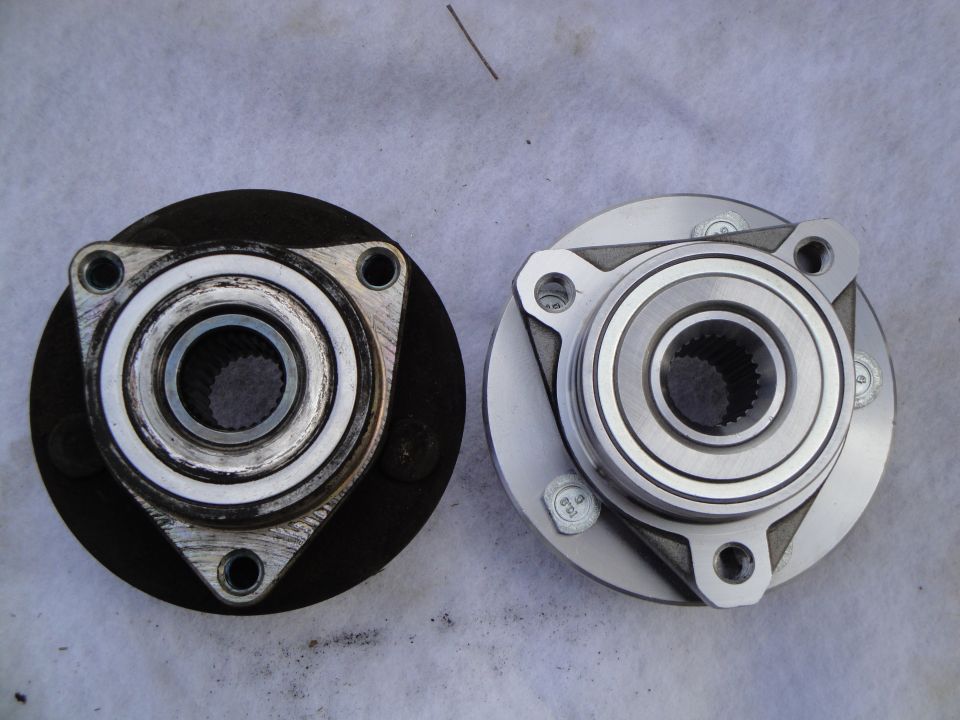 Rear face of used wheel hub bearing beside new replacement with 3-bolt flange