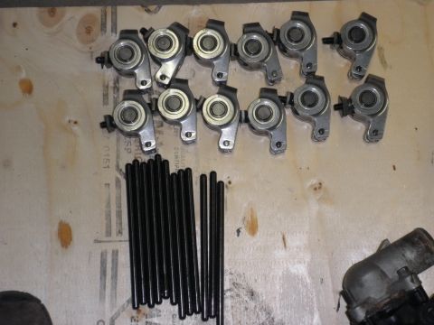 1990 Ford Probe - Engine parts, including rocker arms and pushrods, are laid out on a wooden surface.