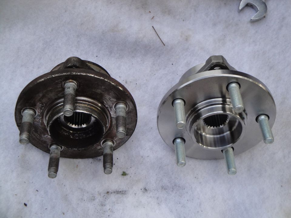 Rusty used 5-stud wheel hub next to new machined hub bearing with wrench