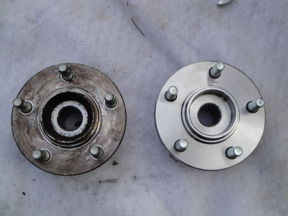 Old corroded 5-lug wheel hub bearing next to a new clean replacement hub