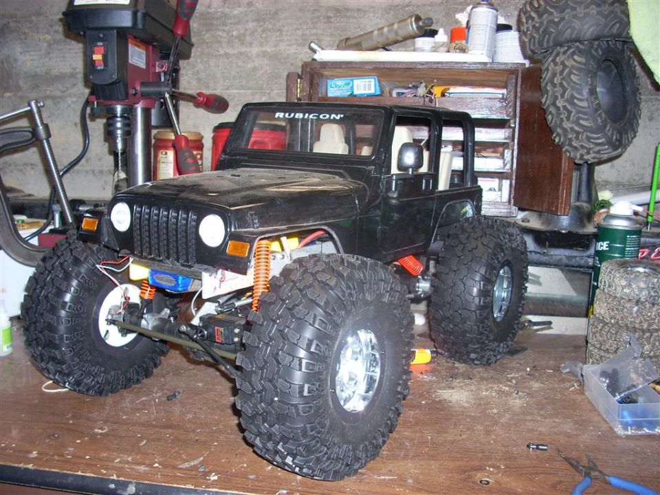 Black Jeep Wrangler with large off-road tires and "RUBICON" text on windshield