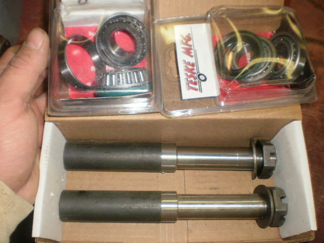Two metal shafts with nuts and bearings in plastic packaging
