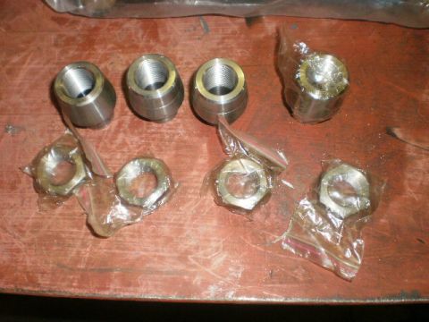1995 Ford Bronco - Several metal threaded fittings and hex nuts are laid out on a wooden surface, possibly for automotive repair or assembly.